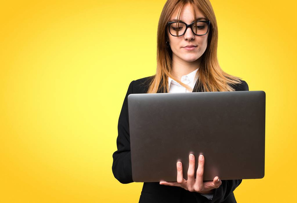 Young business woman with laptop on colorful background - Photo, image