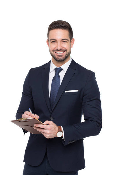 Young caucasian confident businessman writing on clipboard tooth - Zdjęcie, obraz