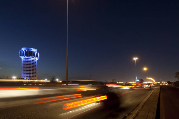 Torre de água Jeddah à noite, com luzes de carro movimento sobre o stree
 - Foto, Imagem