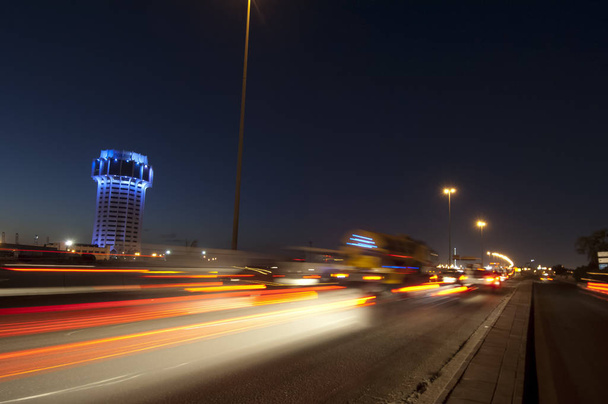 Torre de agua de Jeddah en la noche, con luces de coche movimiento en el stree
 - Foto, imagen