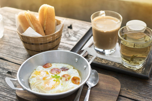 Ontbijt set, brood, warme koffie, ei, omelet en hete thee op wo - Foto, afbeelding