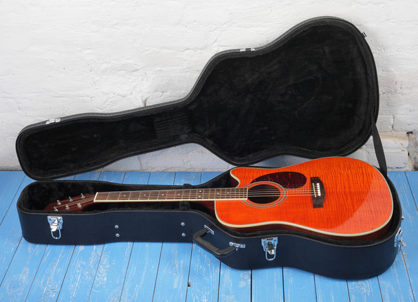 Instrumento musical - Guitarra acústica de chama laranja em caixa dura
 - Foto, Imagem