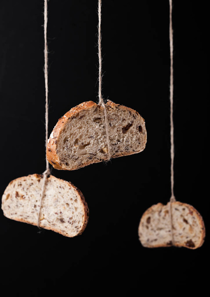 Freshly baked bread with oats hanging on rope - Fotografie, Obrázek