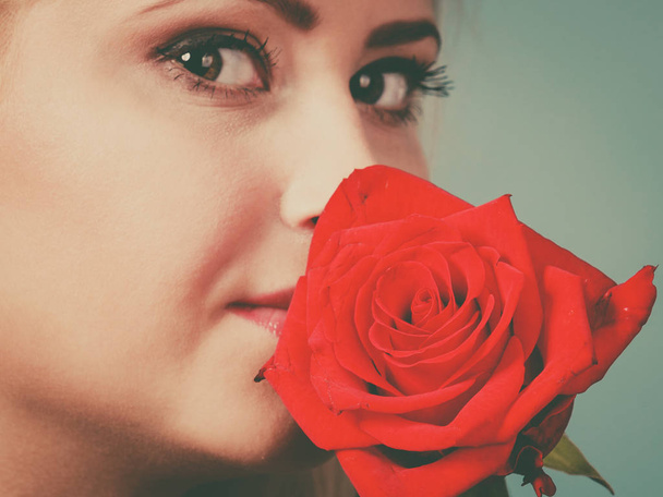Gorgeous woman holding red rose flower. - Valokuva, kuva