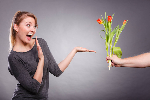 Woman gets bouquet of tulips from man. - Foto, afbeelding