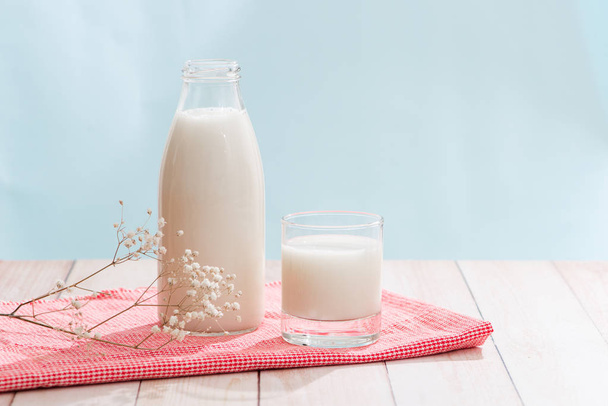 Productos lácteos. Botella con leche y vaso de leche sobre mesa de madera
 - Foto, Imagen