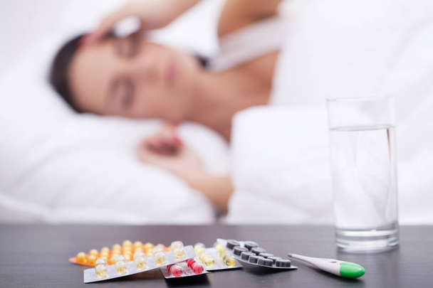 Asleep unhealthy woman and pills on the nightstand - Photo, image