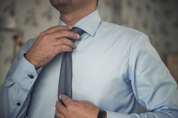 człowiek, dostosowując jego krawat - Zdjęcie, obraz