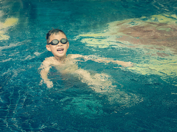 Asian boy is playing in the pool, very happy, vintage style - Foto, Bild