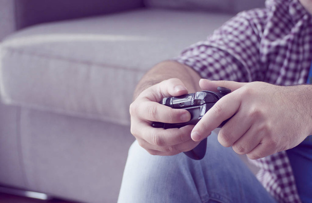 a young man with joystick playing video games at home spending t - Foto, Imagem