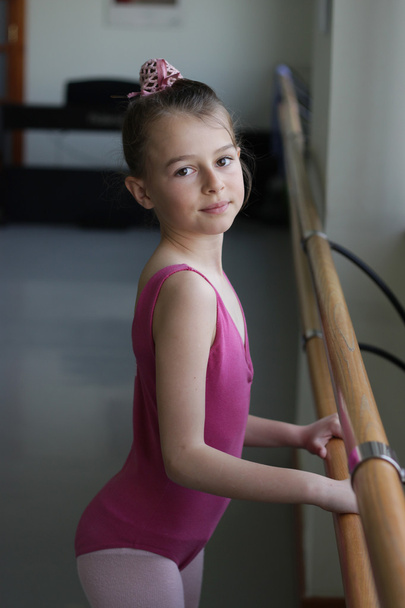 Ballet girl standing next to the barre - Photo, Image