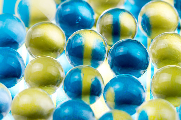 Blue and yellow water gel balls. Macro photo, can be used both for advertising or cosmetics and for medicine. Abstract background. - Foto, afbeelding