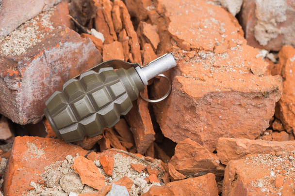 Grenade à main posée sur un mur de briques
 - Photo, image