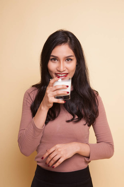 Young Asian woman thumbs up with a glass of drinking water. - Фото, изображение