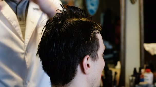 Kampaaja leikkaa asiakkaan parturissa
 - Materiaali, video