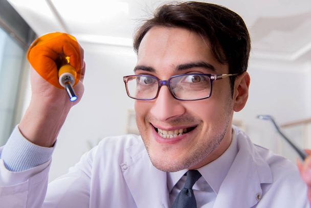 Dentista engraçado com luz de cura no conceito médico - Foto, Imagem