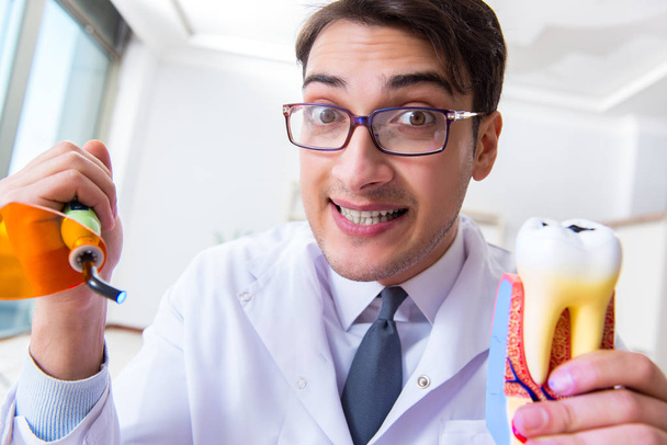 Dentista engraçado com luz de cura no conceito médico - Foto, Imagem