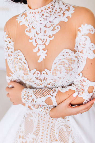 The bride in a beautiful dress with a lace embraces herself - Photo, Image