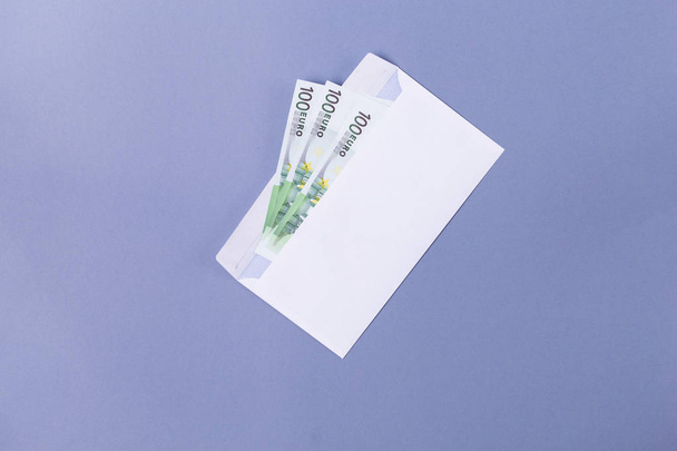 Eurobiljetten in een envelop op een blauwe achtergrond - financiële soncept. - Foto, afbeelding