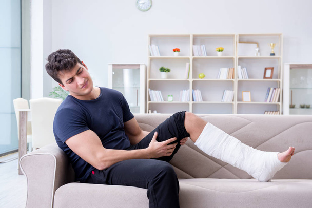 Hombre con la pierna rota recuperándose en casa - Foto, imagen