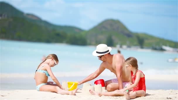 Aile, tropik beyaz sahilde kumdan kale yapıyor.. - Video, Çekim