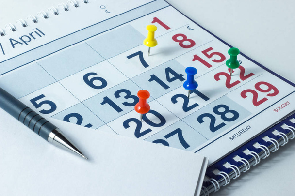 Wall calendar and pen, important days are marked with knops - Φωτογραφία, εικόνα