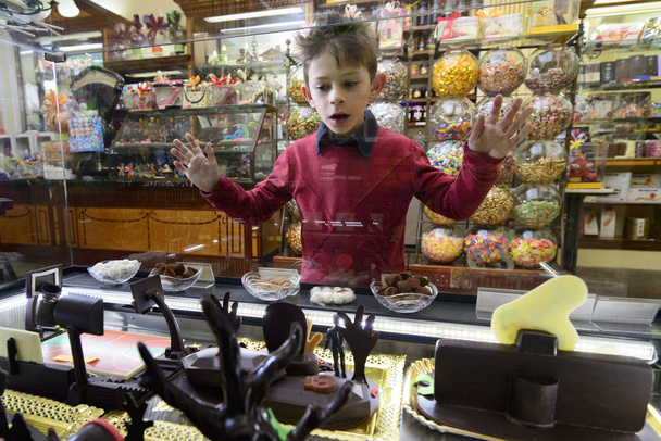 Bambino affascinato nella vetrina del negozio di cioccolato orizzontale
 - Foto, immagini