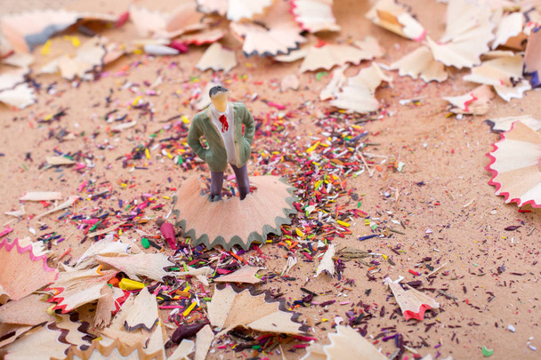 Figurine homme debout au milieu de copeaux de crayon colorés - Photo, image