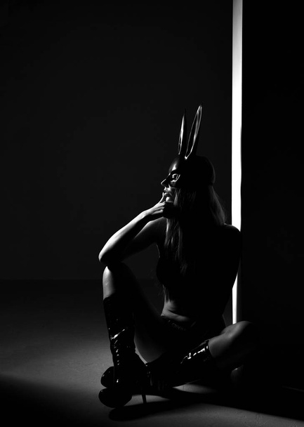 Beautiful sexy woman in rabbit bunny mask sitting on dark - Photo, image