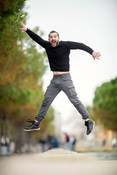 Salta... Emocionado hombre feliz saltando alto, usando ropa casual
 - Foto, Imagen