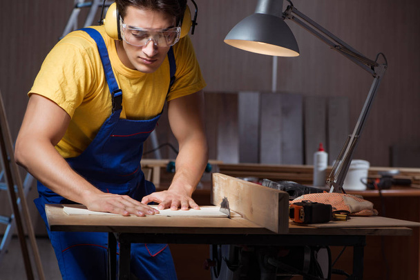 Worker working in repair workshop in woodworking concept - Φωτογραφία, εικόνα