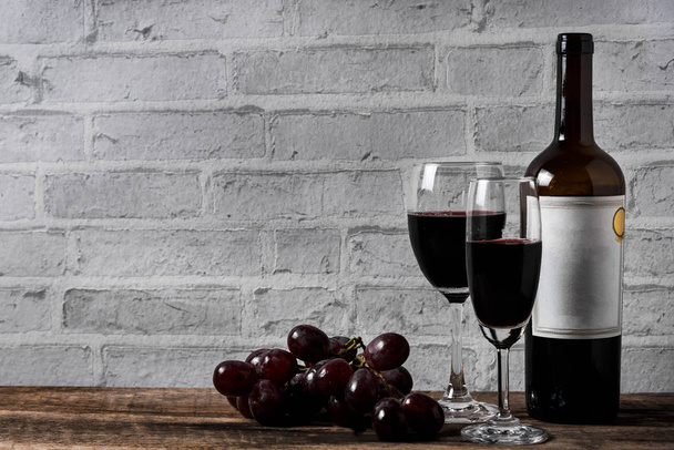wine and grape on wood table white brick background - Foto, imagen