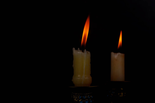 Duas velas de luz queimando brilhantemente no fundo preto
 - Foto, Imagem