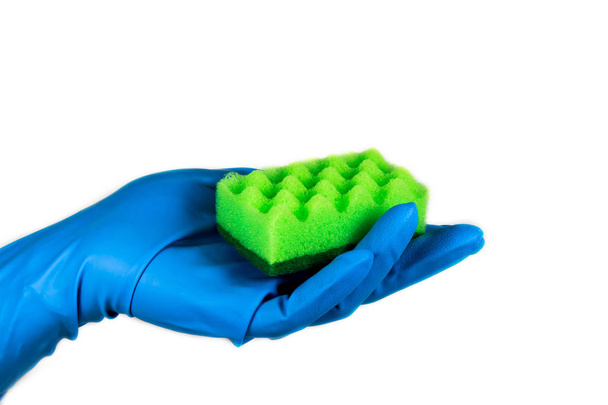 Рука в резиновой синей перчатке с зеленой мочалкой на белом фоне
 - Фото, изображение