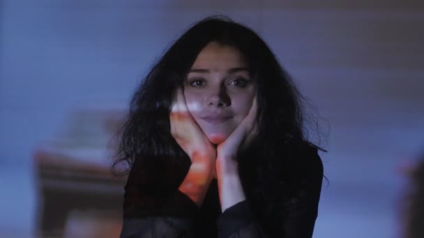 portrait of a young woman watching a video or film on TV or a computer monitor. Reflection on her face - Πλάνα, βίντεο