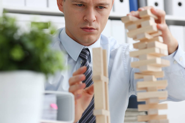 Businessman plays in a strategy of jenga hand - Foto, immagini