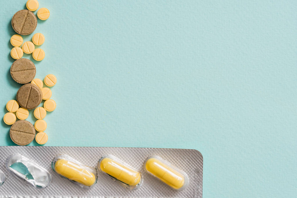 Detalle de Macro shot de comprimidos ovalados amarillos con blisters sobre fondo blanco con espacio para copiar. Medicamento analgésico
. - Foto, imagen