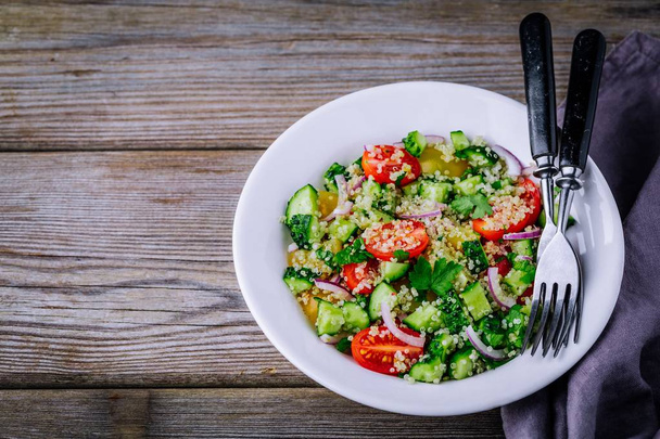 Quinoa Tabbouleh slakom met komkommers, tomaten, rode uien en peterselie - Foto, afbeelding