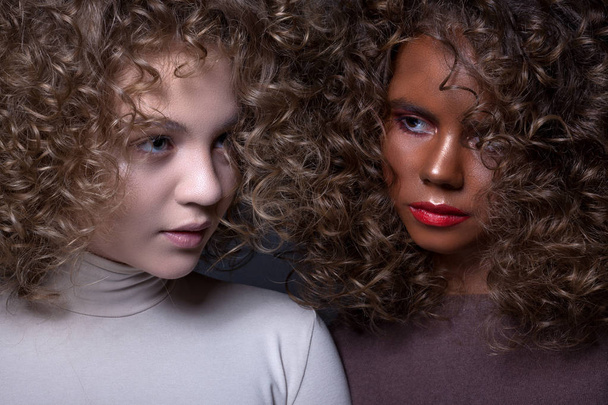 Porträt zweier hübscher Teenager-Mädchen mit Afro-Locken und - Foto, Bild