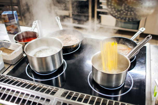egy serpenyőben a víz főzés tészta - Fotó, kép