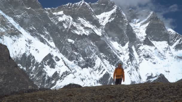 Человек с рюкзаком поднимается на склон горы в Гималаях
 - Кадры, видео