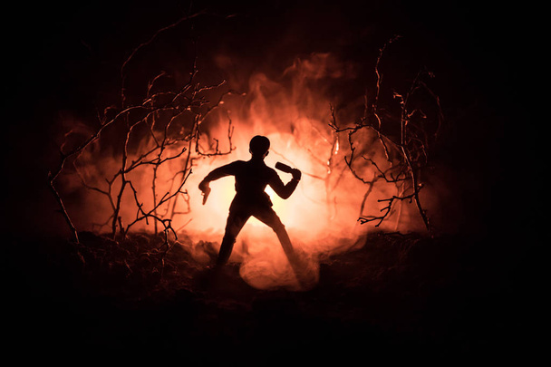 Scenę bitwy. Żołnierz z granatem i niewyraźne zbiornik na tle. Lasu na noc, mistyczny krajobraz surrealistyczne światła z creepy człowieka. - Zdjęcie, obraz