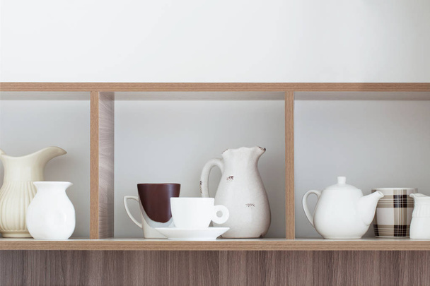 white kitchenware on wooden shelf - Foto, Imagen