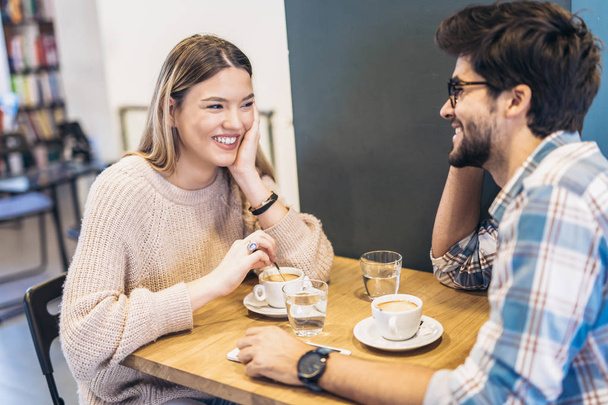 Para, pije kawę przy stoliku w kawiarni - Zdjęcie, obraz