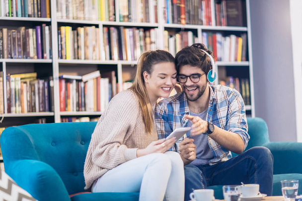 Jeune couple s'amuser et utiliser la tablette numérique à l'intérieur dans le café
 - Photo, image