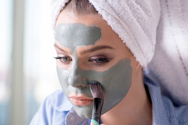 Femme appliquant masque en argile avec brosse à la maison - Photo, image