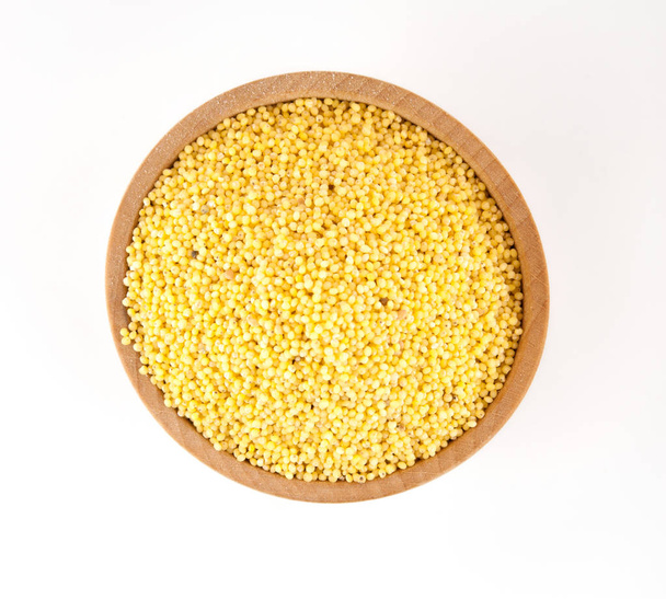 Millet in a wooden bowl isolated on a white background. - Photo, Image
