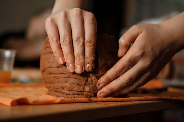 Női kéz, hogy clay pot a kerámia-munkahely. A fazekasműhelyt modellezés keramikus. Közelről - Fotó, kép