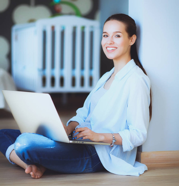 Young beautiful woman at home sitting on the floor with laptop - Foto, Imagem