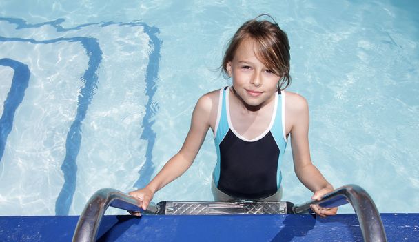 Chica en una escalera que entra en una piscina
 - Foto, Imagen